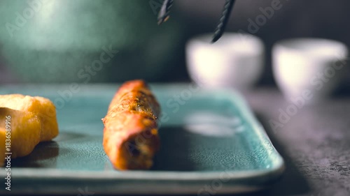 Crispy fried chicken wings, chicken nuggets and beef kebab in a plate. Kebab is Dipped into a Ketchup Bowl on a Table with Black Background a Macro Shot in 4K.