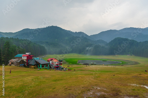 Panoramic view of famous tourist destination Khajjiar, It is green meadow with lake nestled down in the foothills of Dhauladhar ranges of the Western Himalayas.