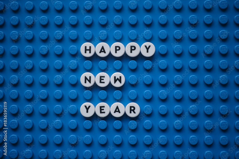 Obraz premium Tambov, Russian Federation - December 06, 2025 The phrase Happy New Year on a blue Lego baseplate. The scene is made out of Lego dots.
