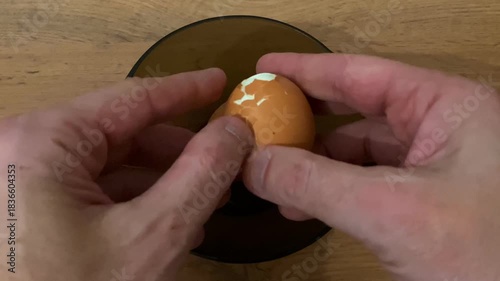Morning kitchen activity involving shell removing from boiled egg