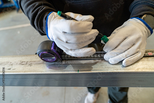 Fotografija Worker hands measuring metal beam marking construction material