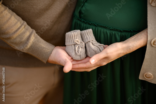 pregnant couple holding hands of the belly of their husband