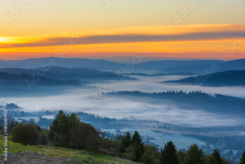 Fototapeta Naklejka Na Ścianę i Meble -  Autumn mountain view and peaceful landscape with fog and sunlight at dawn, Beskid, Poland, natural background or nature photo wallpaper