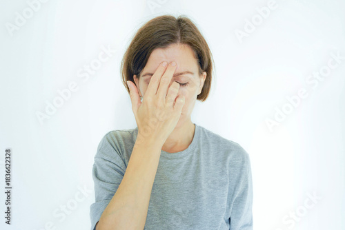 Woman massaging the third eye acupressure point GV 24.5 between eyebrows for migraine relief. Symbolizes energy meridian therapy, traditional Chinese medicine technique, and ancient headache remedy.