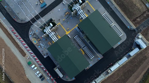 Drone footage capturing vast electrical infrastructure including National Grid transformers, synchronous condenser units, solar panels and overhead power lines in Wisbech UK