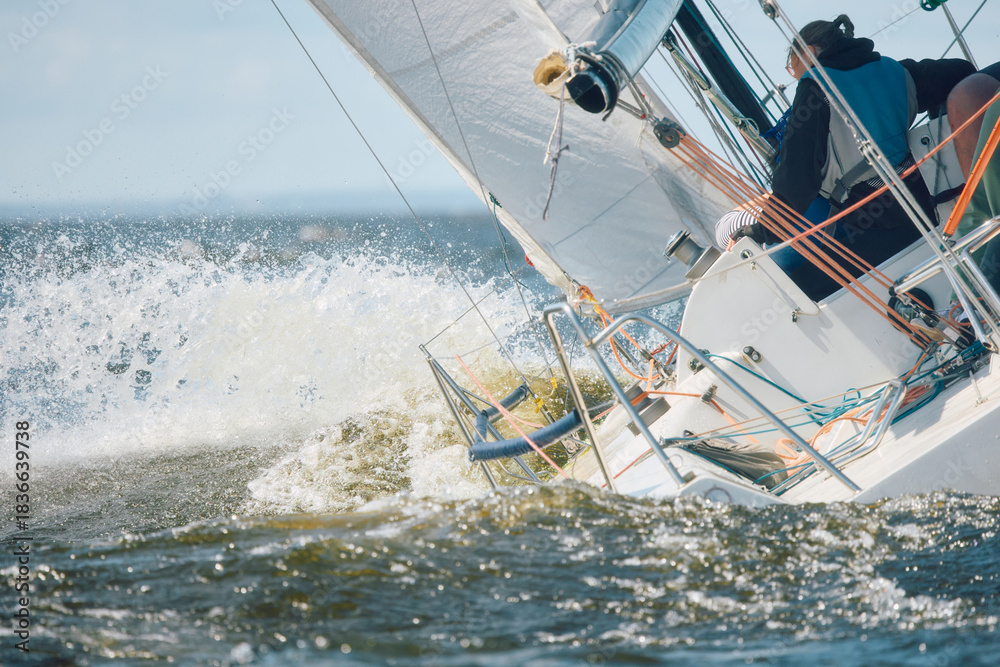 Fototapeta premium Sailing regatta in the Gulf of Finland at sunny day, sailing yacht competing in a race, splashing water from under the boat, teamwork, board the boat