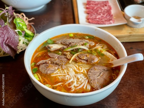 Bild auf Leinwand Authentic Vietnamese noodle soup Bún Bò Huế featuring beef, rice noodles, chili