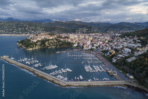 Aerial view of a yacht-filled harbor, with boats docked along a sturdy stone pier and a backdrop of the town, Agropoli, Campania, Italy.