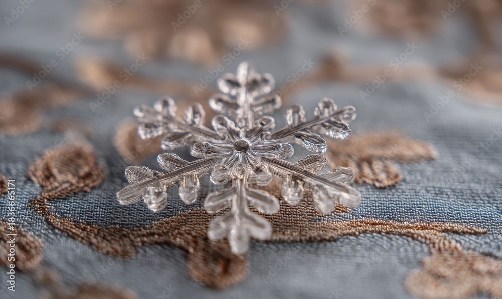 Obraz premium A snowflake is sitting on a blue and brown fabric