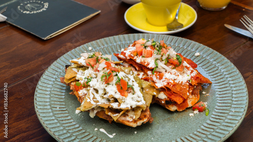 molletes chilaquiles mexicanos con salsa roja y verde acompañados de jugo de naranja / Mexican chilaquiles with red and green sauce and orange juice