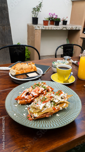 molletes de chilaquiles mexicanos con salsa roja y verde acompañados de jugo de naranja / Mexican chilaquiles with red and green sauce and orange juice