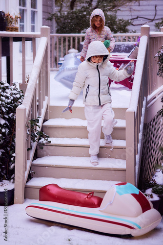 Excited Children Heading Out to Ride Their Inflatable Sled on a Snowy Winter Day, Ready for Active Winter Fun