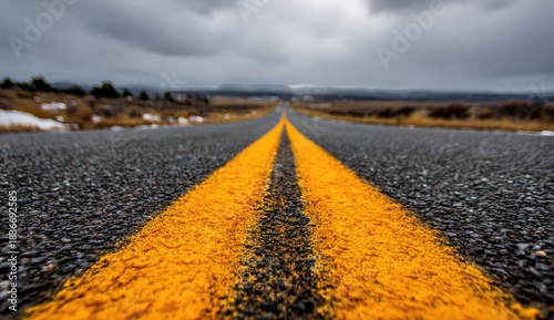 Paved asphalt highway vanishing into a hazy, overcast horizon