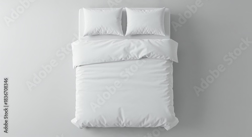 A pristine white bed with two pillows and a duvet is neatly made, viewed from directly above on a clean, light gray background, offering ample copy space.