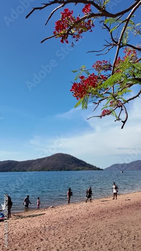 Cape Maclear  Lake Malawi Africa. 01, 12.2025. Video.  Holidaymakers on the sandy beach at Cape Maclear within the Malawi National Park ssouthern Malawi Africa.