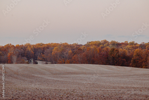 A barn on a farm surrounded by autumn foliage 