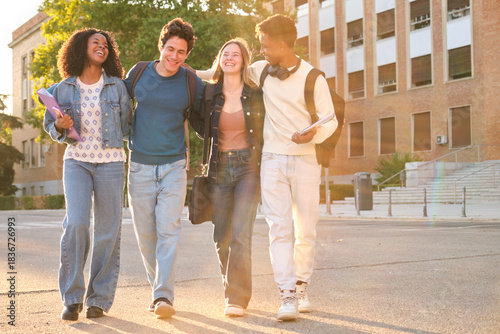Happy young adults enjoying friendship while walking outdoors at sunset