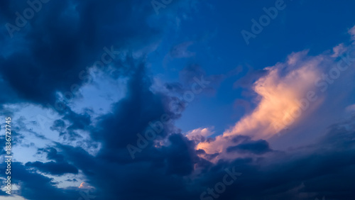 Fotografie Moody sky composition showing dark blue storm clouds contrasting with a patch of