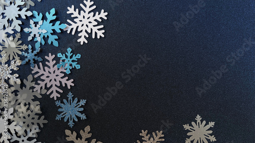 Decoración con papel, copos de nieve y brillos para navidad / invierno en tonos azul para usar como fondo.