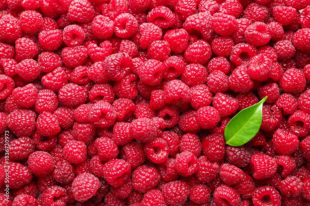 Naklejka premium Fresh ripe raspberries and leaf as background, top view