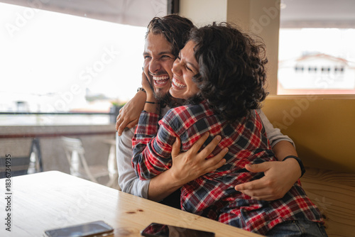 LGBTQ+ friends sharing a warm laugh and tight hug