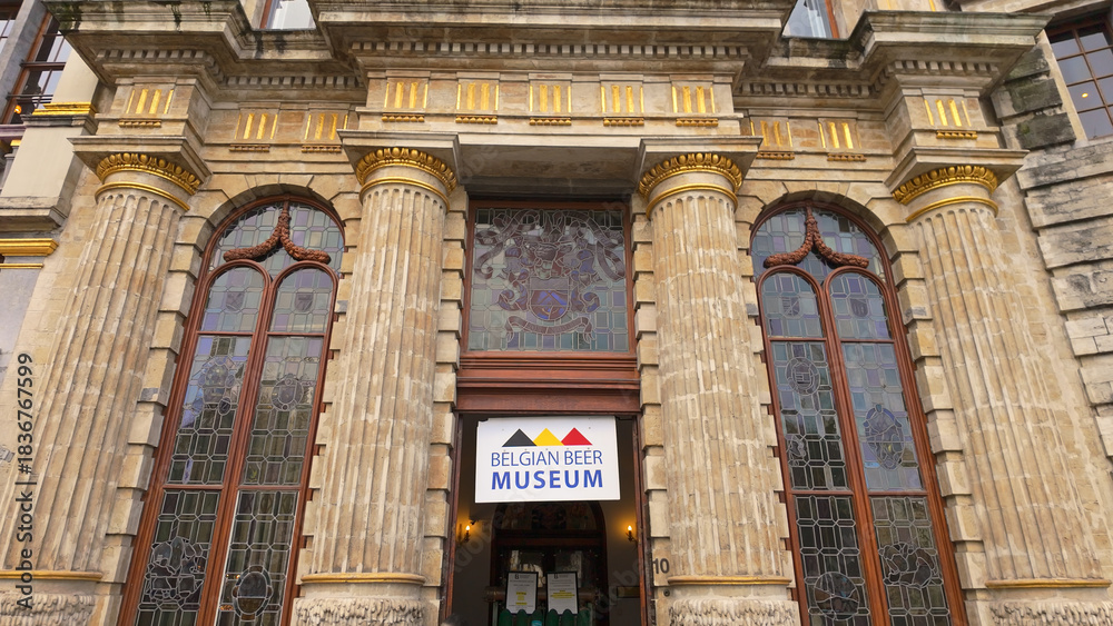 Naklejka premium BRUSSELS, BELGIUM - NOVEMBER 26, 2025 - Historic building facade with columns and Belgian Beer Museum sign