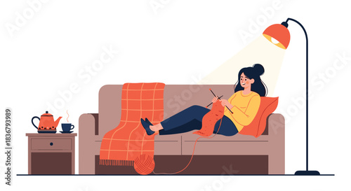 A cozy scene of a woman relaxing on a sofa under a warm lamp, enjoying her knitting hobby with a cup of tea nearby.