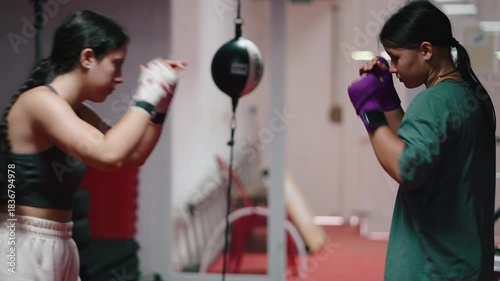 Two female boxers sparring together in a gym