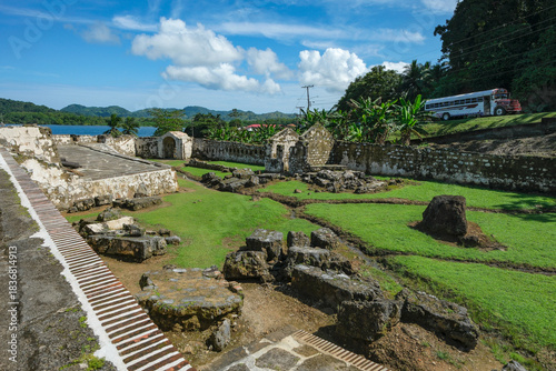 Portobelo, Panama - December 6, 2025: A bus passing by the ruins of Fort Santiago in Portobelo, Panama.