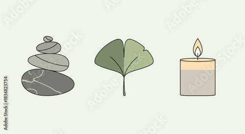 Stacked Zen stones ginkgo leaf and lit candle for relaxation.