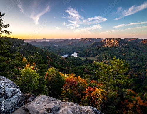 Scenic overlook of a river winding through vibrant autumn forest at sunset