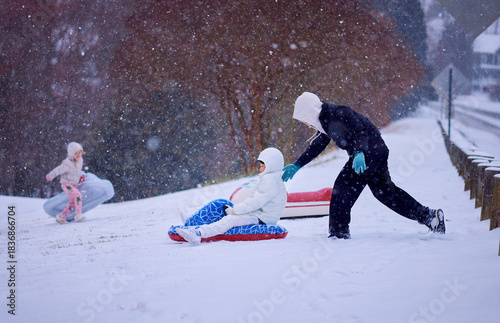 Children Sledding Down a Snowy Hill – Winter Fun in Motion under Soft Falling Snow. Active Family Snow Day