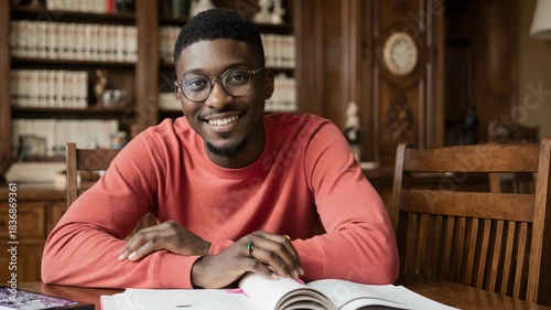 Happy Black Man Smiling at Camera in a Cozy Library or Cafe