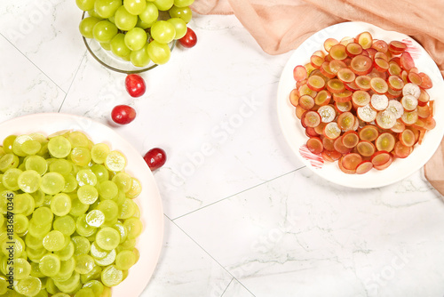 Fresh Green and Red Grapes with Sliced Fruits on Marble Background