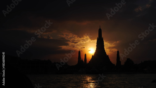 Dramatic Sunset Silhouette of Wat Arun (Temple of Dawn) over Chao Phraya River, Bangkok