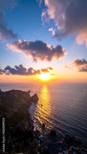 Spectacular sunset over ocean cliffs with vibrant colors and dramatic clouds.