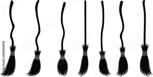 A collection of black witch s brooms with varying handle shapes displayed together