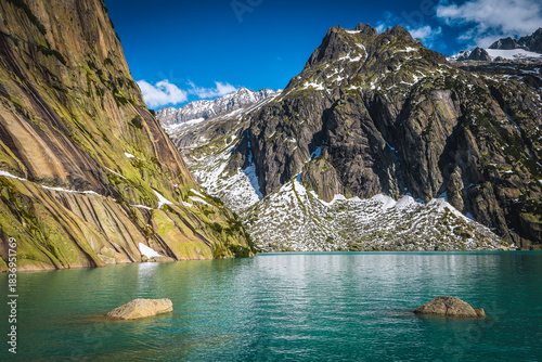 Gelmersee lake and snowy mountains in background, Grimsel Pass, Switzerland