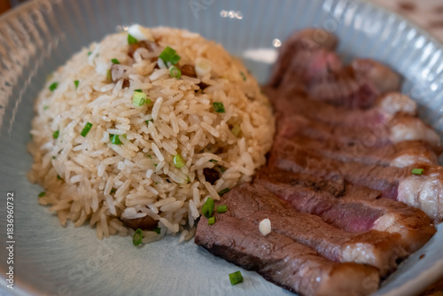Beef fat fried rice with sliced meat served on plate