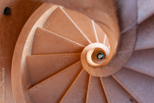 Spiral stone staircase close-up in Al Zubarah Fort, Qatar: warm sandstone steps coiled into circular elegance