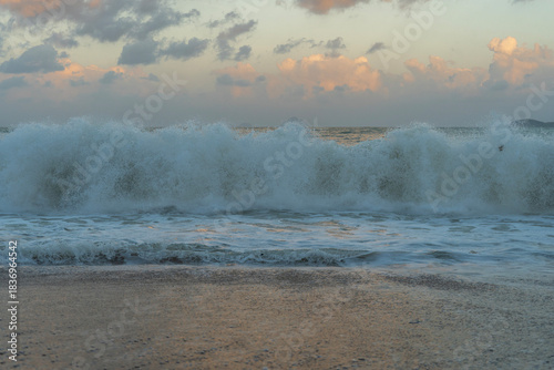 Beautiful sunset over the ocean with dramatic clouds and  wave.