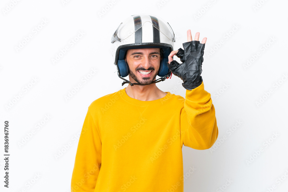 Fototapeta premium Young caucasian man with a motorcycle helmet isolated on white background showing ok sign with fingers
