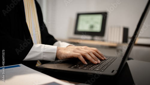 Canvas Print A legal professional wearing a robe types on a laptop beside a gavel and Lady Justice statue, focusing on modern international, cyber, and data protection law cases