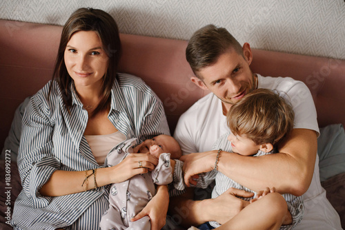 Happy Family Relaxing Together With Newborn Baby