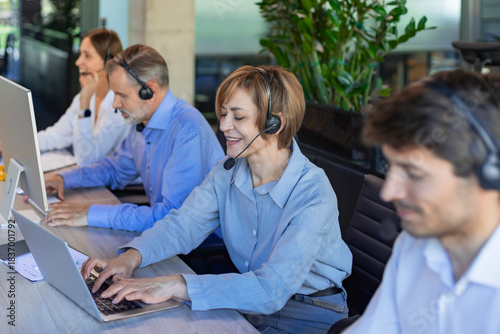 Portrait of happy smiling female customer support phone operator at workplace.