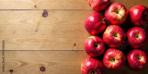 A vibrant arrangement of red apples on a rustic wooden surface, showcasing their juicy texture and rich color, creating a visually appealing composition for various applications.