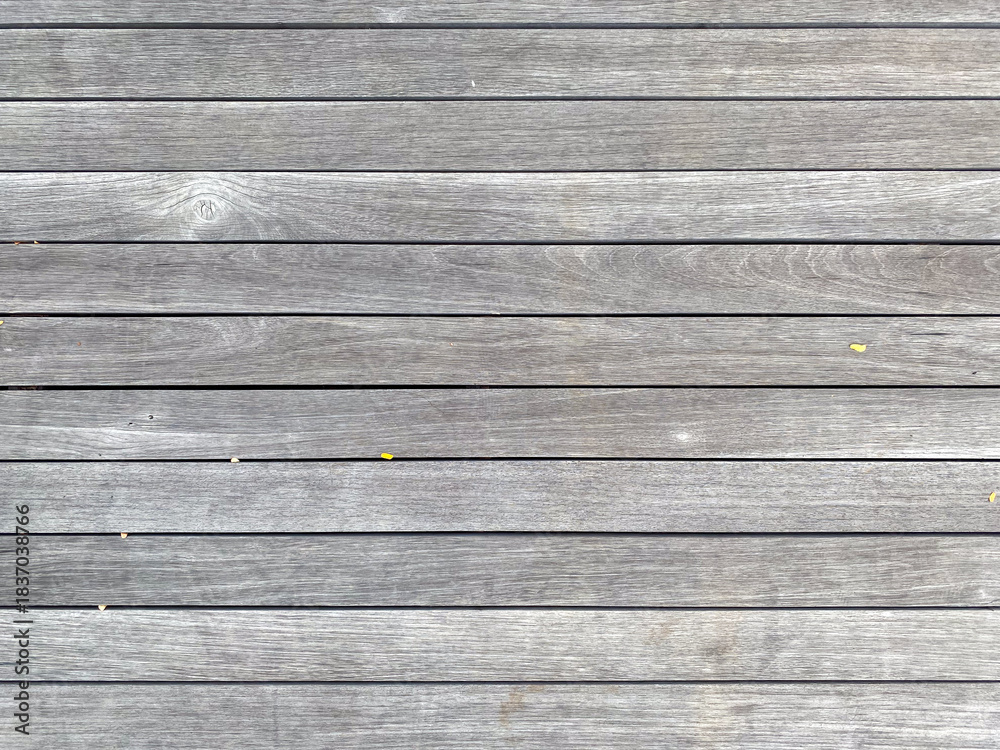 Obraz premium Horizontal close-up texture of a deck floor made of aged wooden planks with faded gray color and natural grain details.