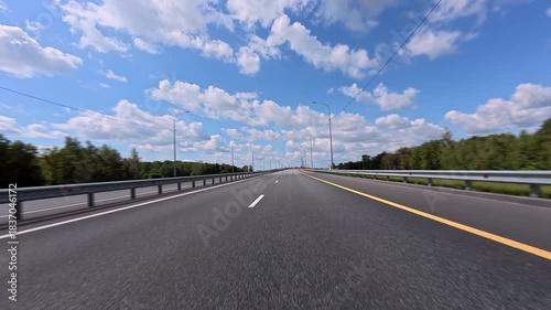 Driving on an empty road in a car, with markings on the asphalt and a lane divider