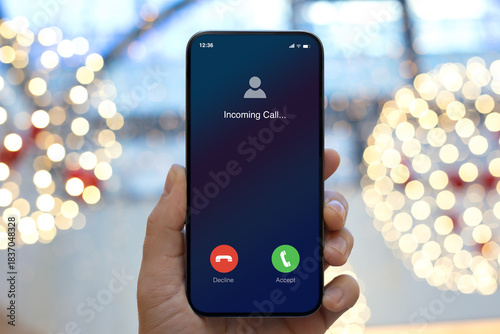 man hand hold phone with incoming call on screen Christmas