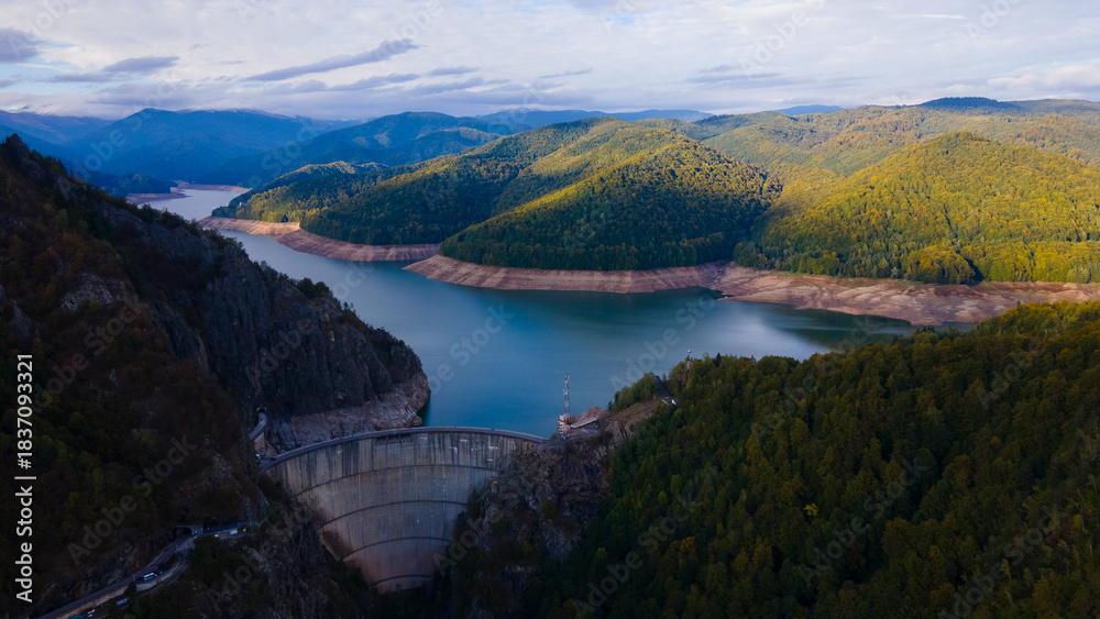 Obraz premium Aerial photography of Vidraru dam, in Romania. Photography was shot from a drone from above canyon at Vidraru lake with the dam and the lake in the view and mountains in the background.